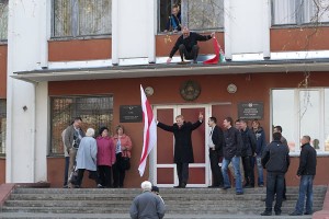 Сяргей Каваленка усталяваў бел-чырвона-белы сцяг на Кастрычніцкім судзе Віцебска. Фота Сержука Серабро