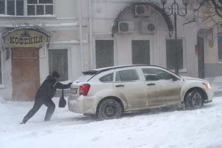 Милиция с народом. Прапорщик следовавший куда-то пешим порядком остановился чтобы помочь даме, автомобиль которой забуксовал в снегу. Фото Сергея Серебро