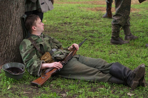 Боец Вермахта, вооруженный винтовкой Mauser 98k, отдыхает положив под голву пилотку M35. Реконструкция боя за Витебск. Фото Сергея Серебро