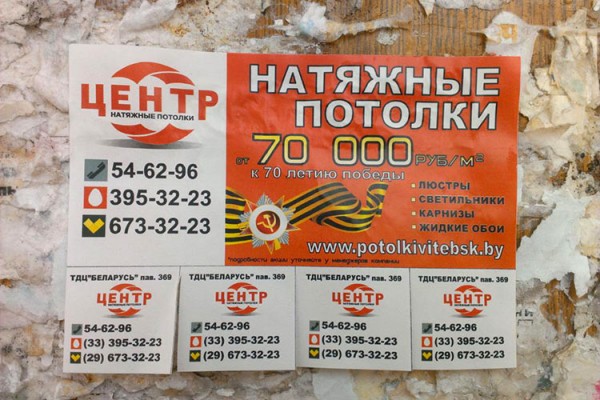 Объявление с праздничной акцией на натяжные потолки. Фото Сергея Серебро