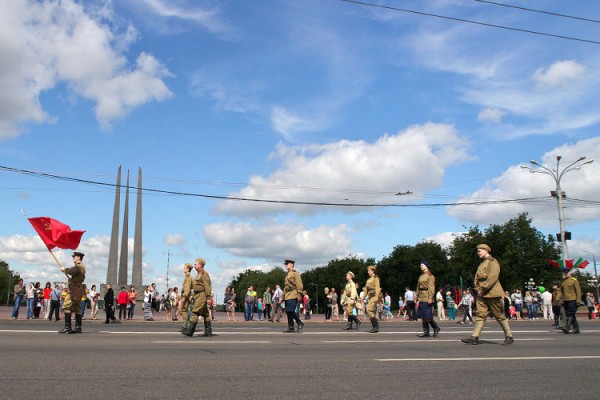 Красное знамя во главе колонны реконструкторв в форме РККА времен Второй мировой войны. Тетрализованное шествие в Витебске во время празднования дня города. Фото Сергея Серебро