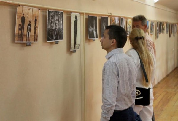 Зрители рассматривают работы на фотовыставке. Фото Юрия Шепелева
