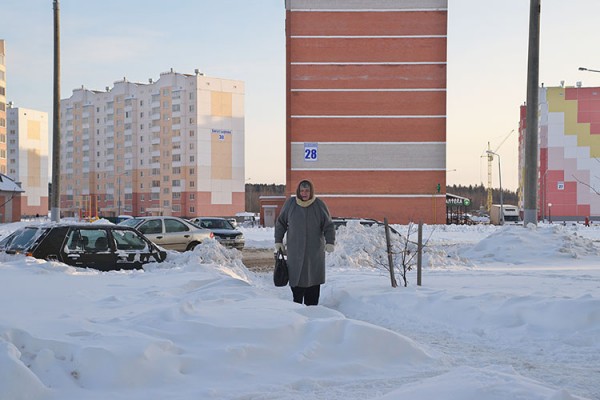 Пожилая женщина идет по тропинке среди сугробов в Билево. Фото Сергея Серебро