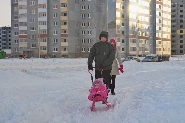 Родители везут ребенка в санках по тракторной колее в Билево. Фото Сергея Серебро