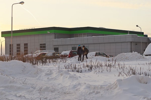 Молодые люди пробираются через сугробы у магазина в Билево. Фото Сергея Серебро