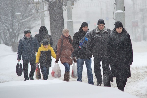 Пешеходы пробираются между сугробами к остановке общественного транспорта на Замковой улице. Последствия циклона «Даниэлла» («Daniella») в Витебске. Фото Сергея Серебро