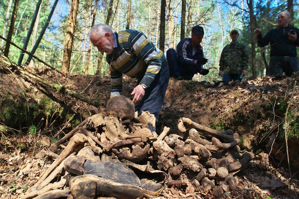 Барыс Хамайда падлічвае знойдзеныя на дне магілы на месцы мяркуемых масавых расстрэлаў выкапаныя чалавечыя косці, 2015 год. Фота Сержука Серабро