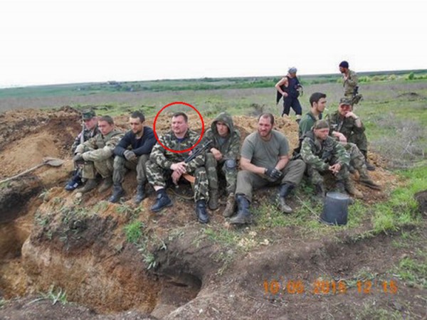 Виктор Калина с автоматом среди неизвестных вооруженных людей рядом со стрелковой ячейкой