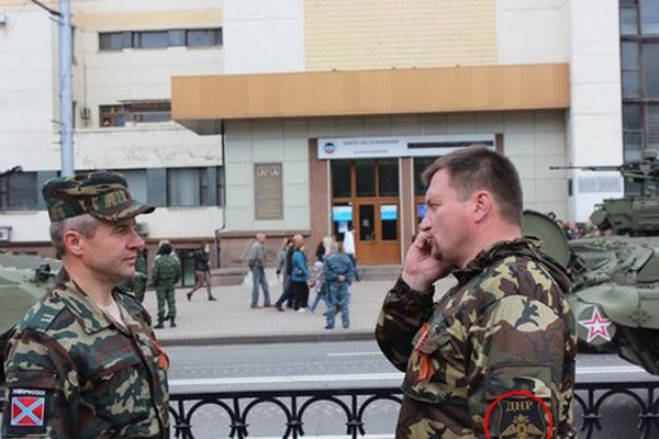 Виктор Калина в камуфляжной униформе с нашивкой ДНР на фоне боевой техники