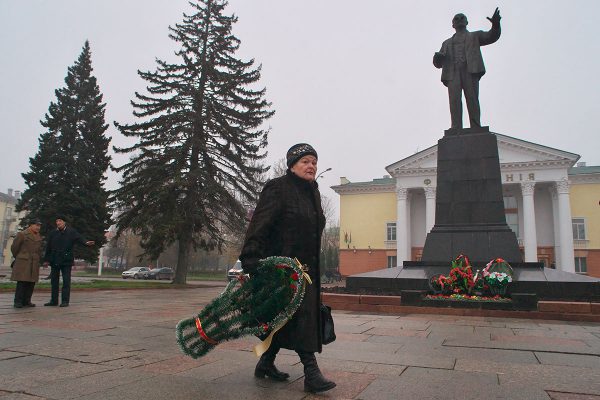 пожилая женщина несет венок к памятнику Ленину в Витебске. Фото Сергея Серебро