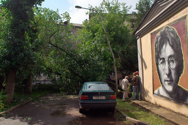 Сотрудники МЧС распиливают дерево. упавшее во дворе дома №1 на улице Кирова. Фото Сергея Серебро