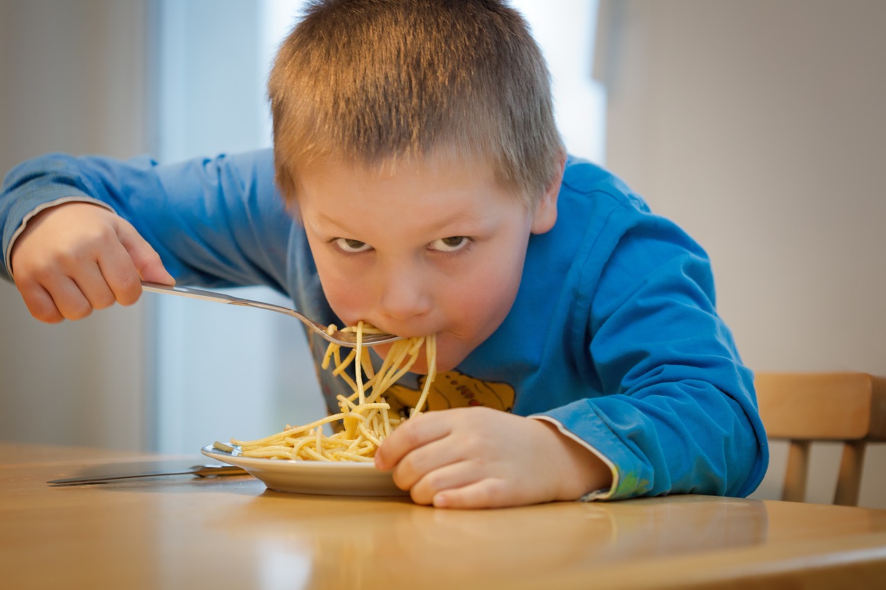 Мальчик ест макароны. Фото pixabay.com