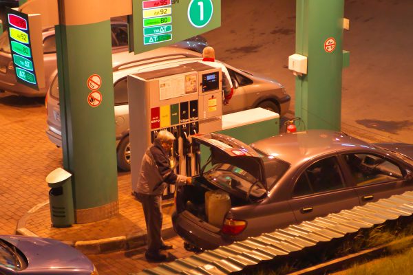 Водитель заливает бензин в канистры накануне подорожания автомобильного топлива. Фото Сергея Серебро