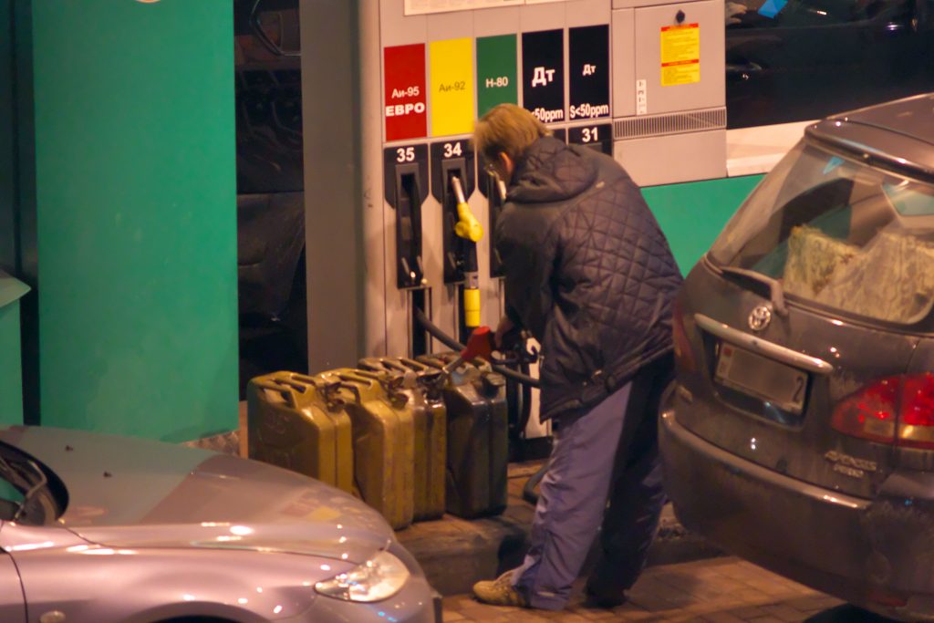 Водитель заливает бензин в канистры накануне подорожания автомобильного топлива. Фото Сергея Серебро