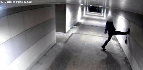 Мужчина разбивает ногой плитку в подземном переходе. Кадр из видеозаписи камеры наблюдения