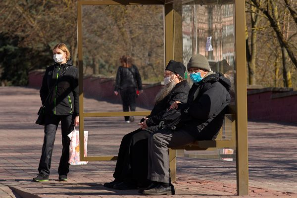 Жители Витебска в медицинских масках ожидают общественный транспорт на остановке. Фото Сергея Серебро