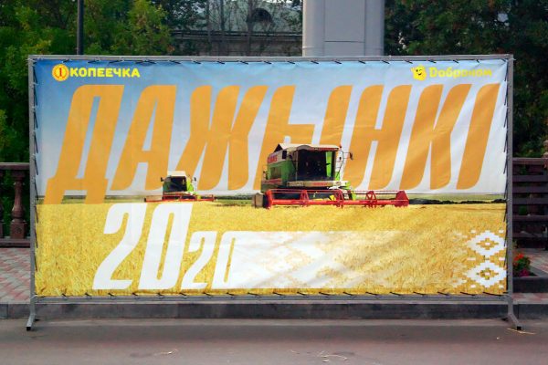 На баннере «Дожинок», установленном на площади Свободы в Витебске, почему-то изображены комбайны немецкого производства, а не белорусского. Фото Сергея Серебро